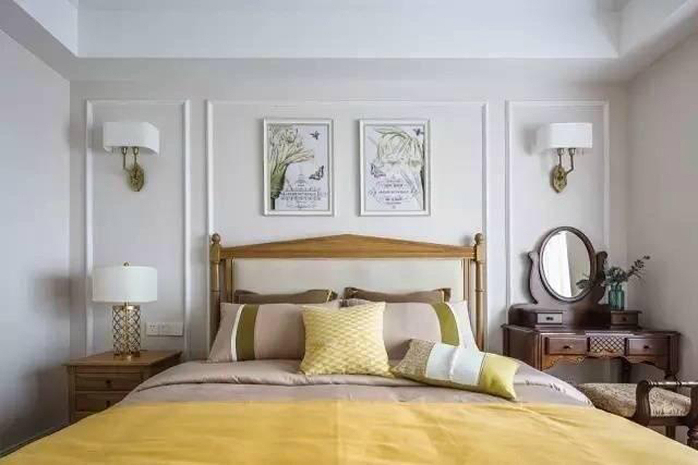卧室的布置较为温馨，作为主人的私密空间，主要以功能性和实用舒适为考虑的重点，美式的装修中，一般卧室不设顶灯，多用温馨柔软的成套布艺来装点，且尽量做到只见光不见灯的效果。同时在软装和用色上非常统一。墙面主要以白色为主，墙上的壁灯，和床头的台灯，也都是以白色为主，看似颜色单一，实则美观大方。